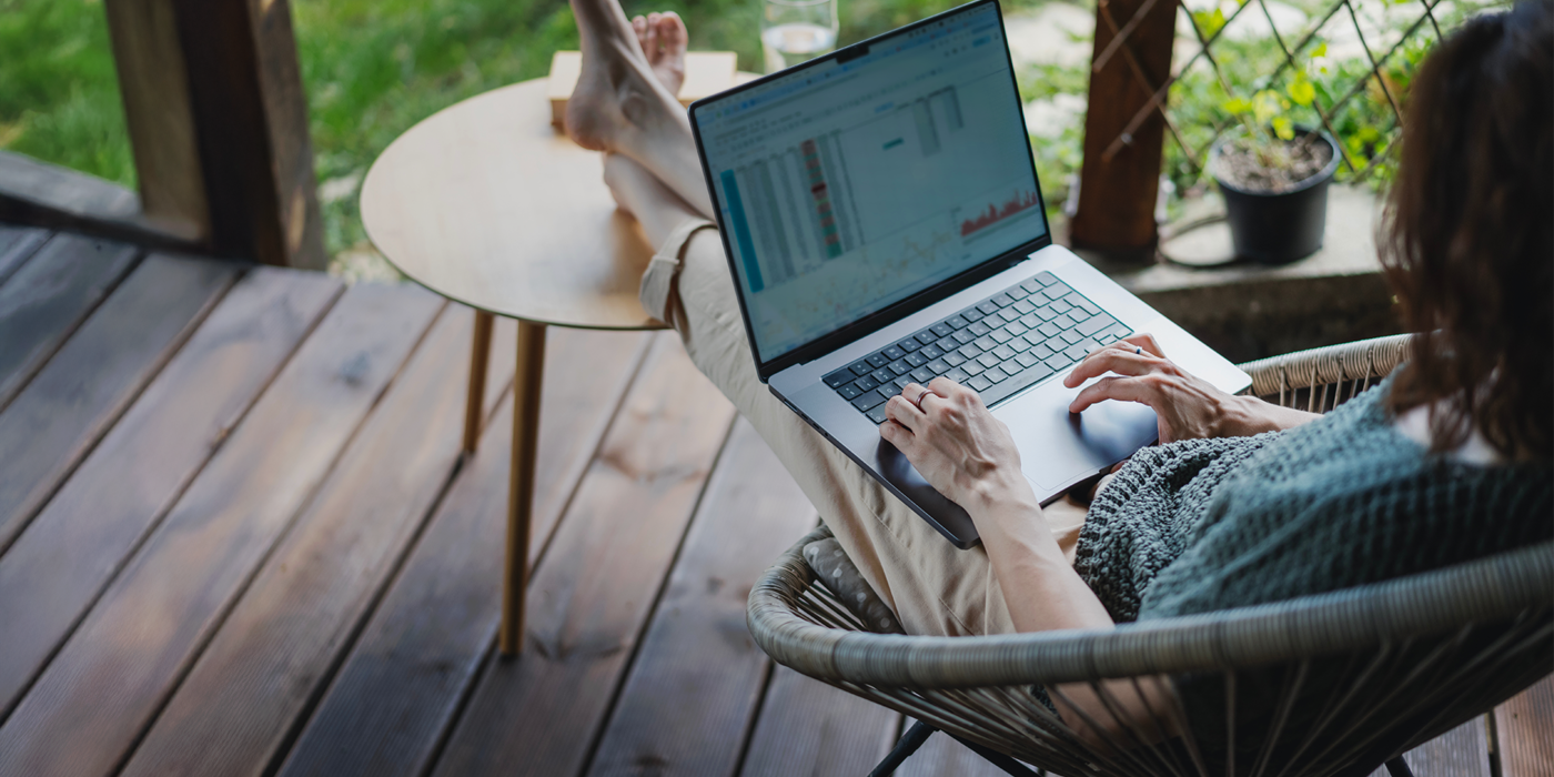 Eine Person arbeitet barfuß auf einer Terrasse mit Laptop und analysiert Internetdaten – Symbol für Freiheit, Homeoffice und schnelle Verbindungen durch Glasfaser.
