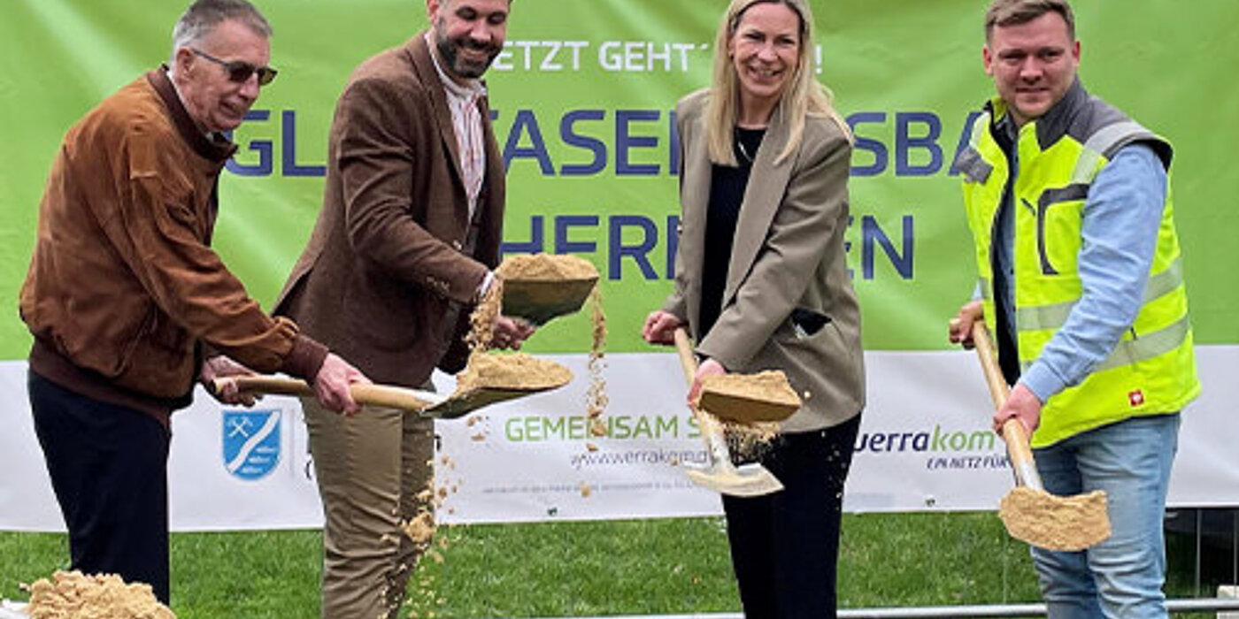 Projektbeteiligte mit Spaten in der Hand vor einem Sandhaufen