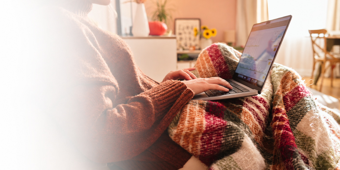 Gemütliche Herbststimmung mit Laptop und warmer Decke