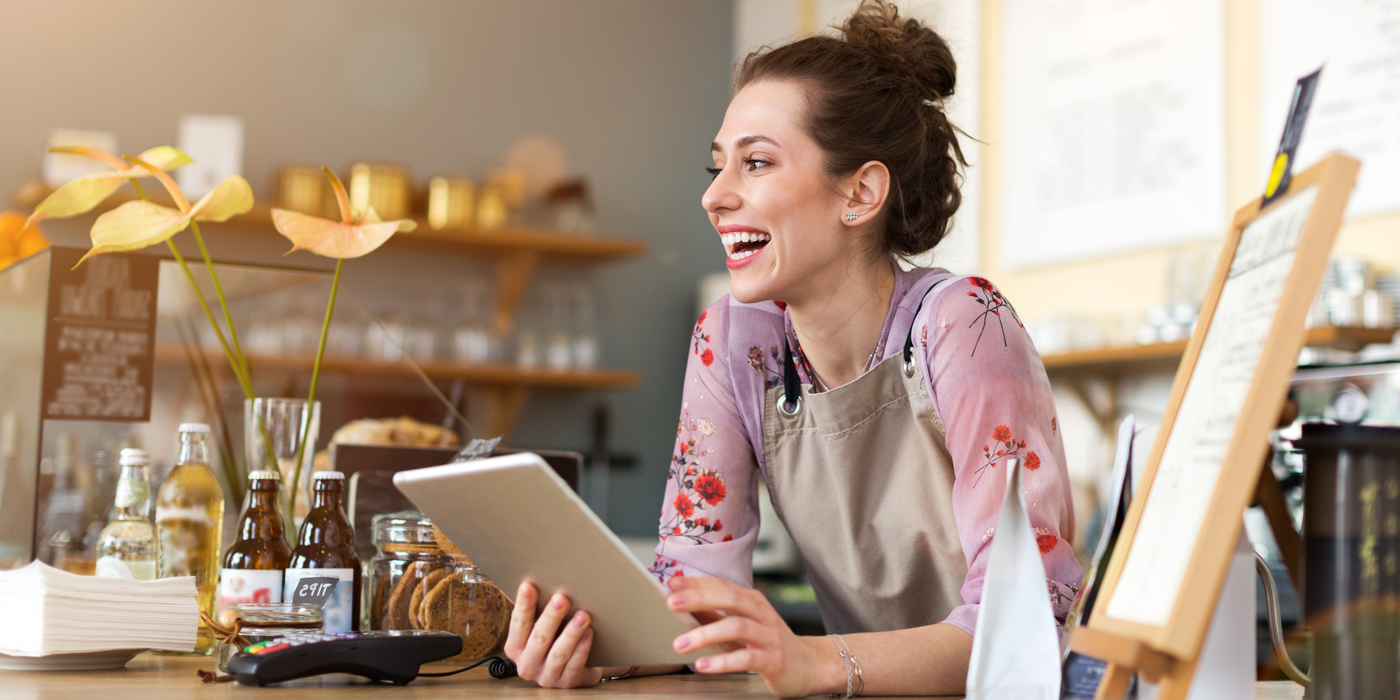 Mitarbeiterin in einem kleinen Unternehmen nutzt ein Tablet im Arbeitsalltag – Symbol für stabiles Internet, digitale Anwendungen und zuverlässige Glasfaseranbindung für Geschäftskunden.