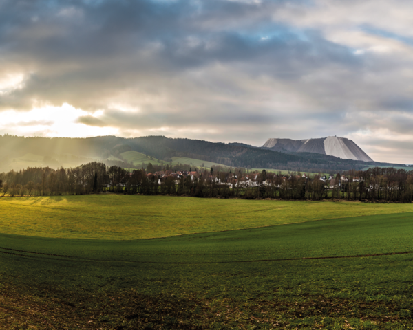 Panoramablick auf Heringen mit Feldern, Wald und dem Kaliberg im Hintergrund – Symbol für regionale Glasfaseranbindung bis ins Haus.