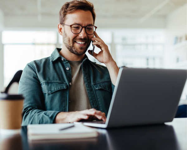 Beratung Person arbeitet am Laptop und telefoniert im Büro